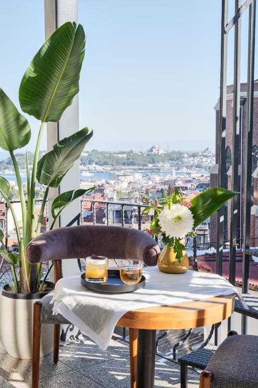 a table with two drinks on a balcony with plants at GentleTom in Istanbul