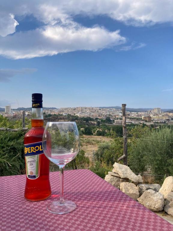 butelkę wina i kieliszek wina na stole w obiekcie Casa Zupparda Noto w mieście Noto Marina