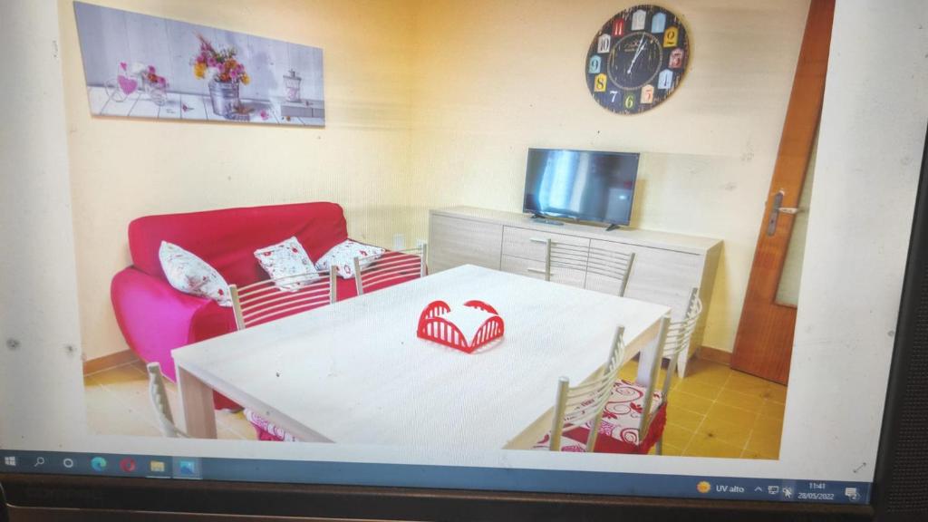 a living room with a white table and a red chair at Polibio 56 in Siracusa