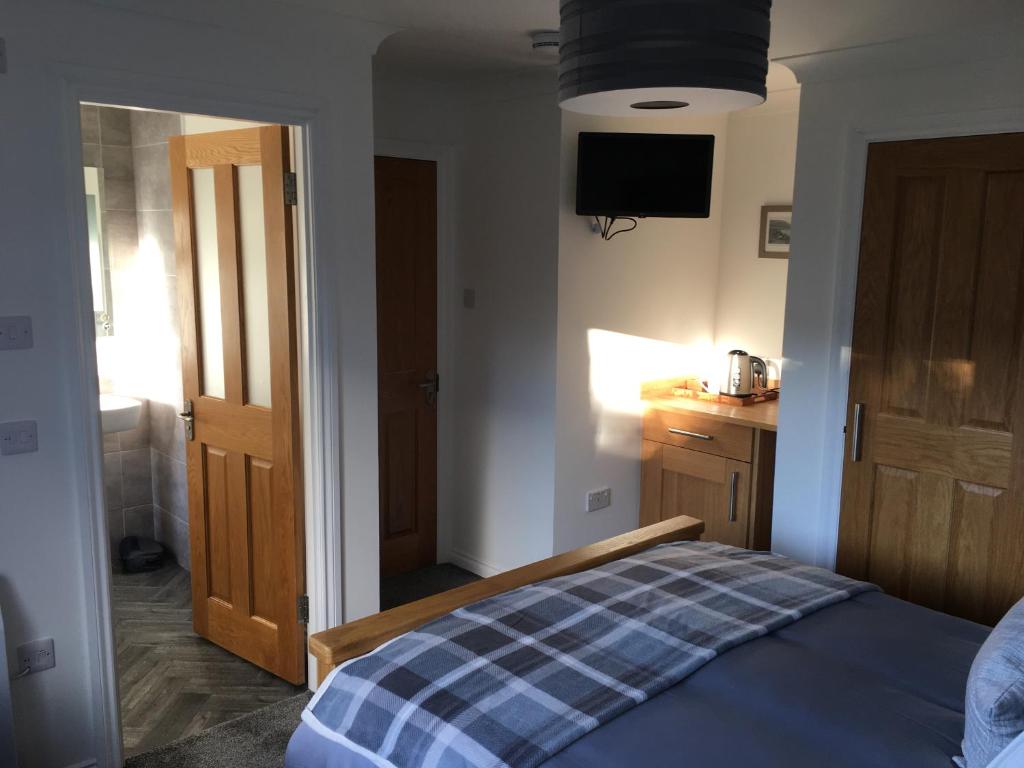 a bedroom with a bed and a tv on the wall at Brecbennoch in Oban
