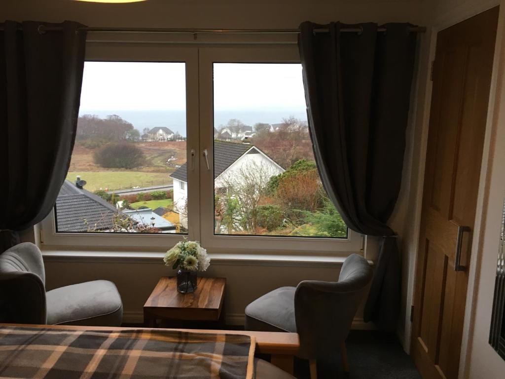 a room with a large window with a table and chairs at Brecbennoch in Oban