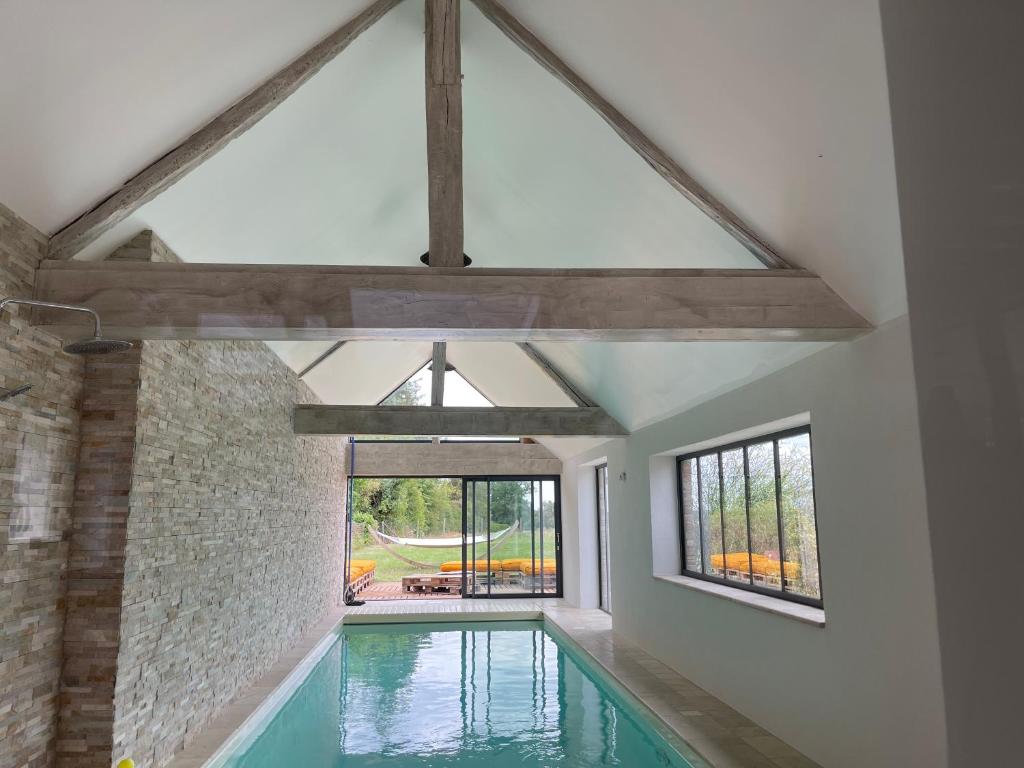 een zwembad in een huis met een groot raam bij Le QG 28 in Nonvilliers-Grandhoux