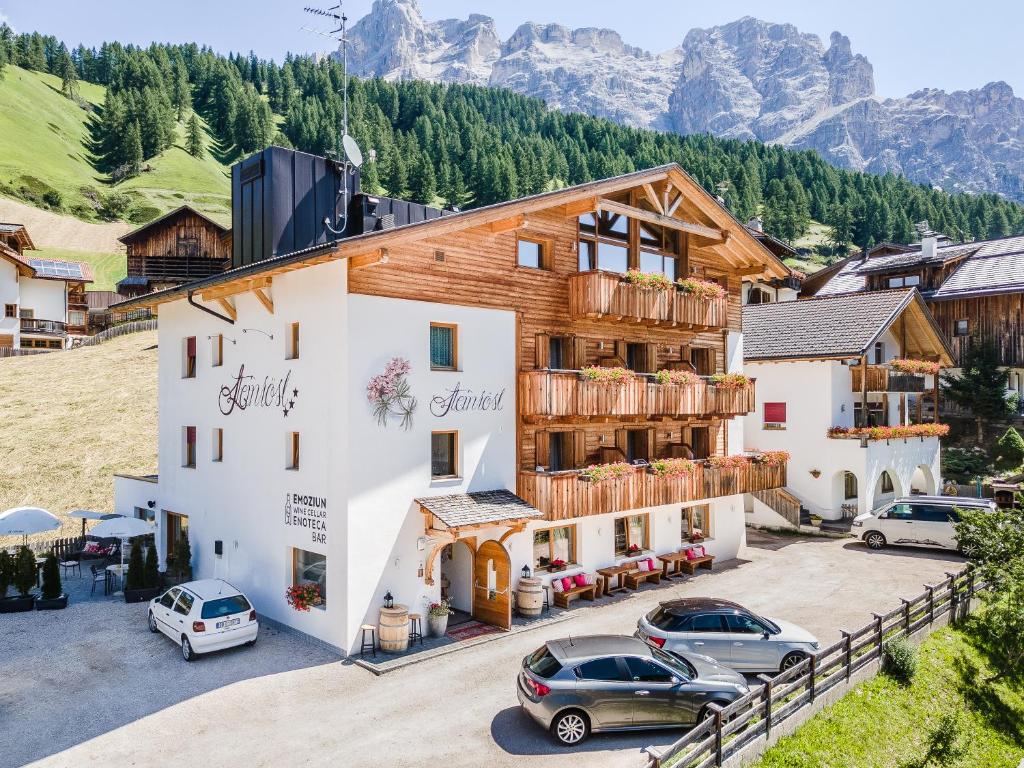 a hotel with cars parked in a parking lot at Hotel Steinrösl in San Cassiano