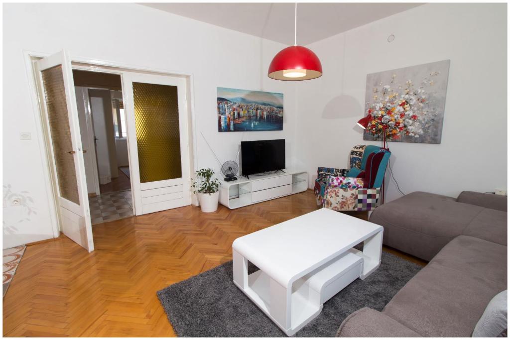 een woonkamer met een bank en een tafel bij Large apartment between Split and Trogir in Kaštela