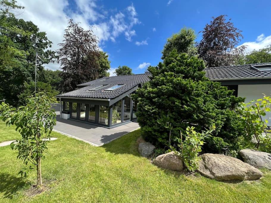 a house with a solarium in a yard at Gemütliches Haus zwischen Förde und Golfplatz in Heikendorf