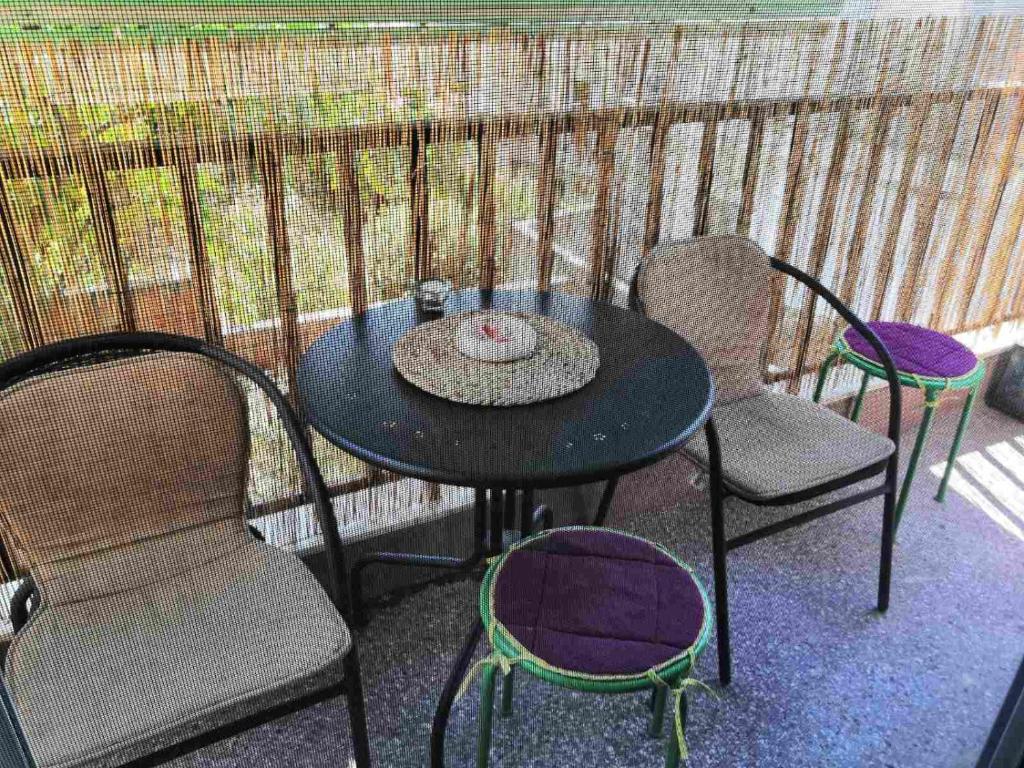 a table and chairs on a balcony with a table and chairs at D apartment in Nea Kallikrateia