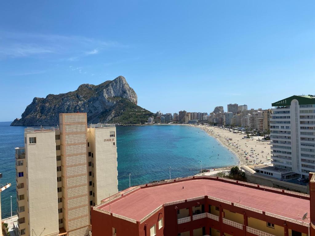 a view of a beach with buildings and a mountain at Estudios HORIZONTE BEACH in Calpe