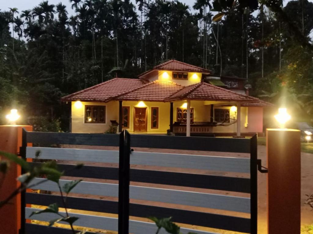 a house with lights in front of a fence at Nandanam Villa in Kaniyāmbetta