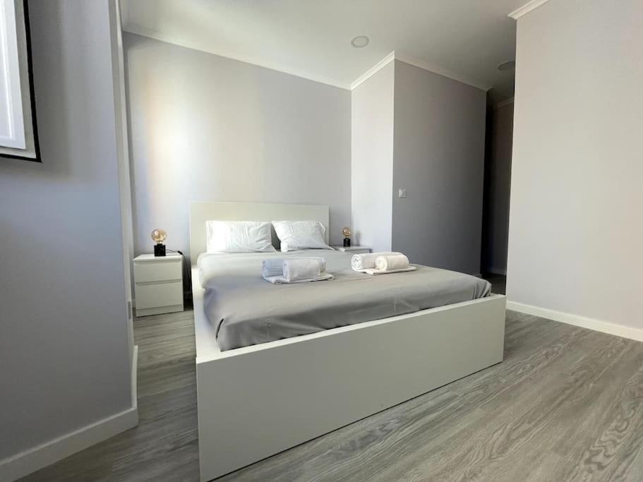 een witte slaapkamer met een groot bed. bij CASA ALCOCHETANA in Alcochete