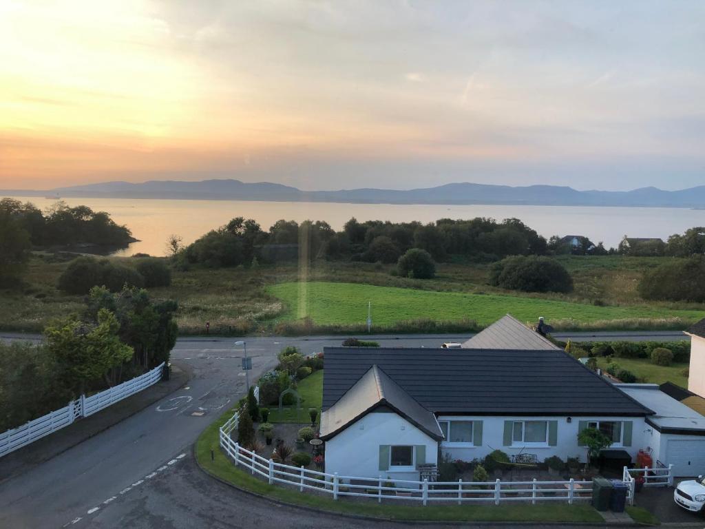 a house on the side of a road with a lake at Brecbennoch in Oban