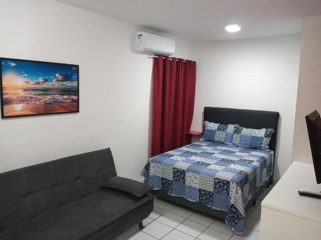 uma sala de estar com uma cama e um sofá em Sala living na Av da Praia. em Santos
