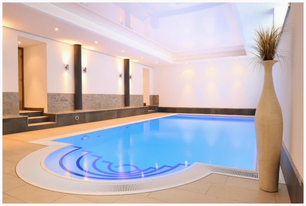 a large swimming pool in a room with a vase at Dappers Wellness Hotel in Bad Kissingen