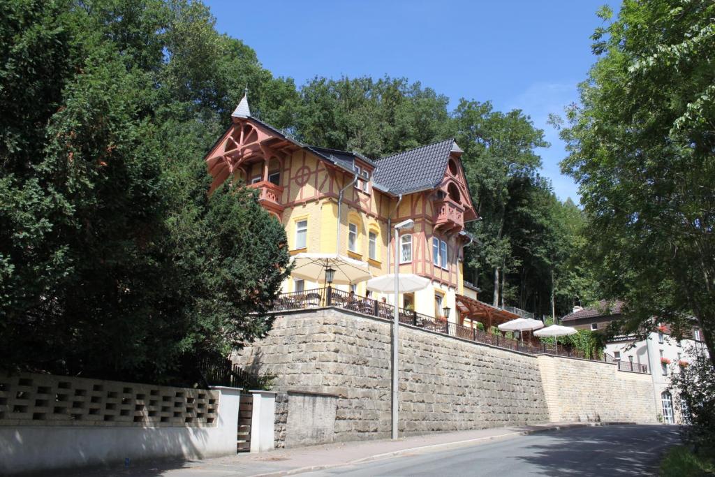 una gran casa de madera en una pared de piedra en Hotel Restaurant Zwergschlösschen, en Gera