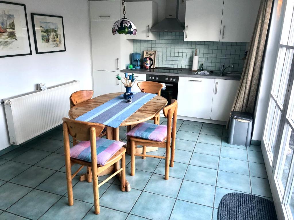 ヴァーネミュンデにあるStrandbummelhausのキッチン(木製テーブル、椅子付)