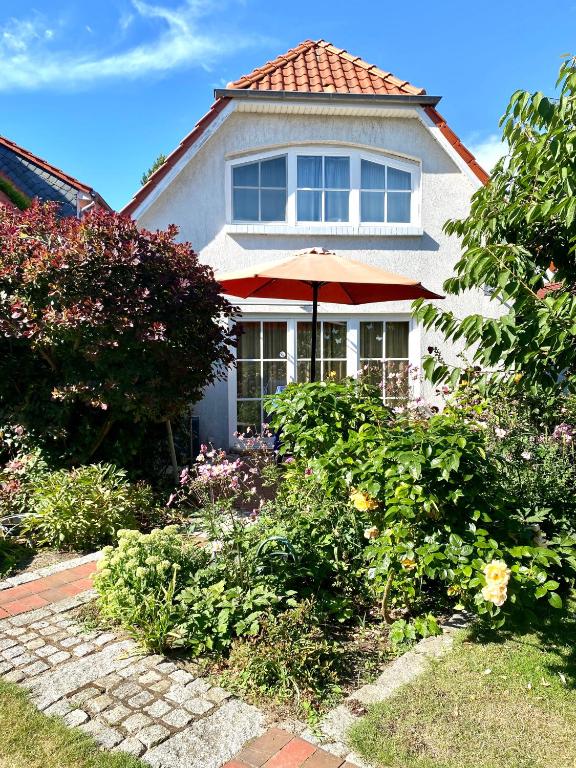 a house with an umbrella in the front yard at Strandbummelhaus in Warnemünde