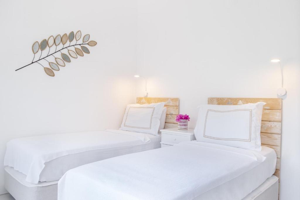 two beds in a white room with white walls at Yasos Suites in Çeşme