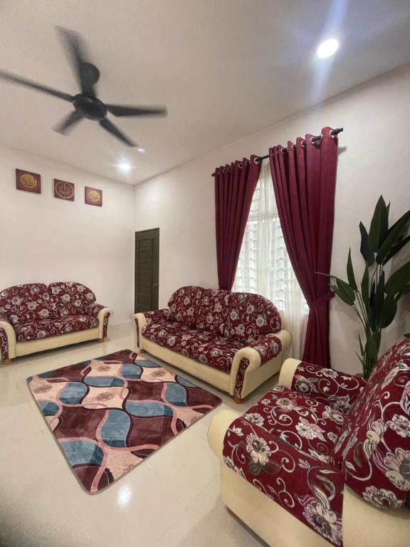 una sala de estar con 2 sofás y una alfombra en HOMESTAY BANDAR KANGAR (NS FAMILY HOMESTAY) en Kangar