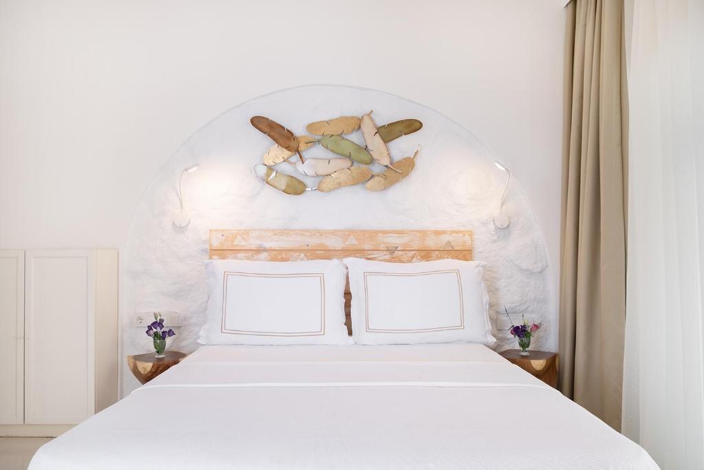 a bedroom with a white bed with two pillows at Yasos Suites in Çeşme