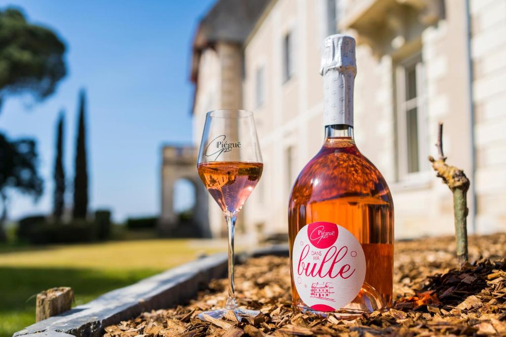 a bottle of wine and a glass in a pile of leaves at Vignoble Château Piéguë - winery in Rochefort-sur-Loire