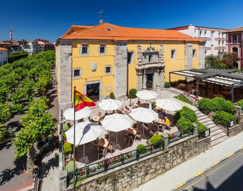 una vista aérea de un edificio con mesas y sombrillas en Don Paco en Llanes