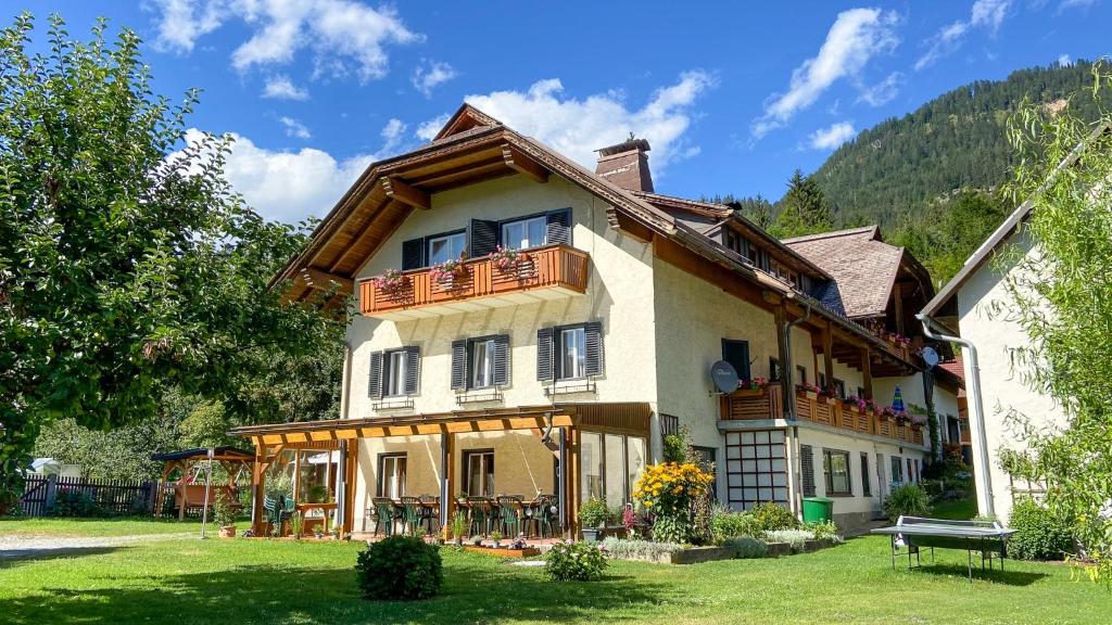 uma casa grande com uma varanda em cima em Gästehaus Rader em Weissbriach