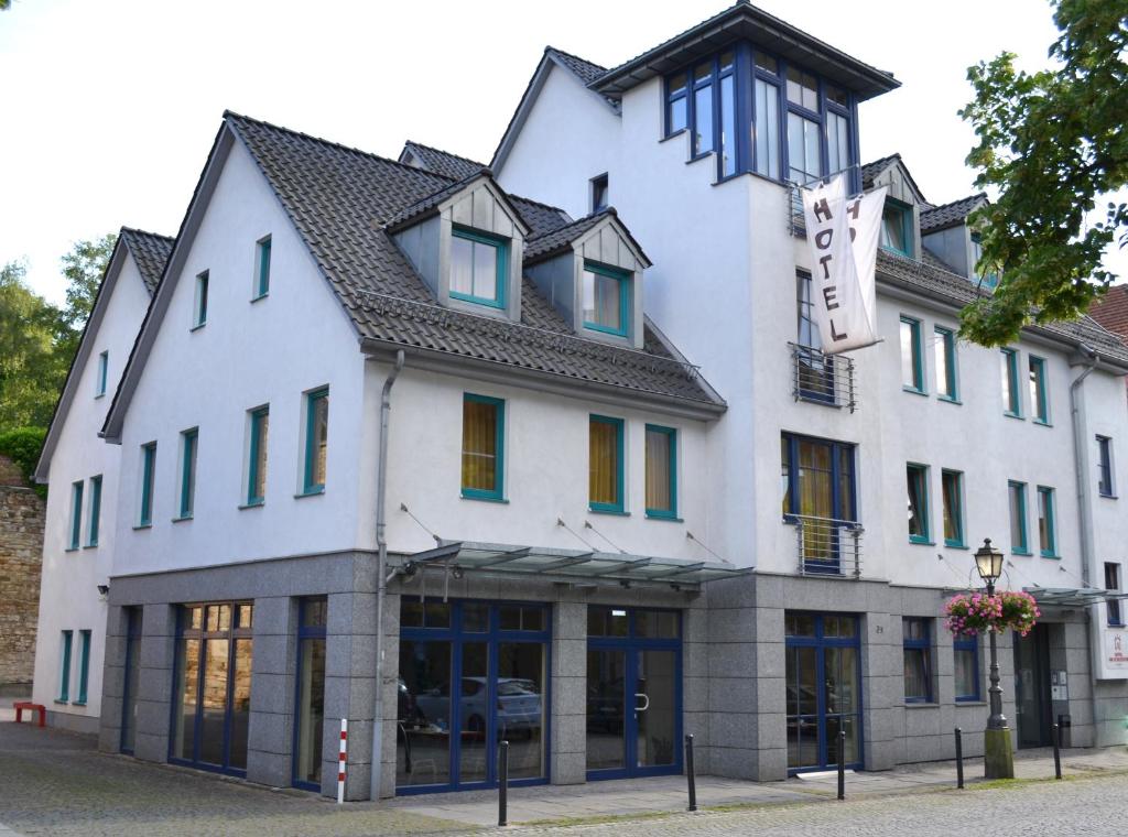 biały budynek z czarnym dachem w obiekcie Hotel Am Schlosstor w mieście Bückeburg