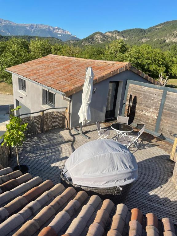 une maison avec une baignoire et une table sur une terrasse dans l'établissement Sublime studio de caractère ,50 m2 climatisé ., à Montlaur-en-Diois