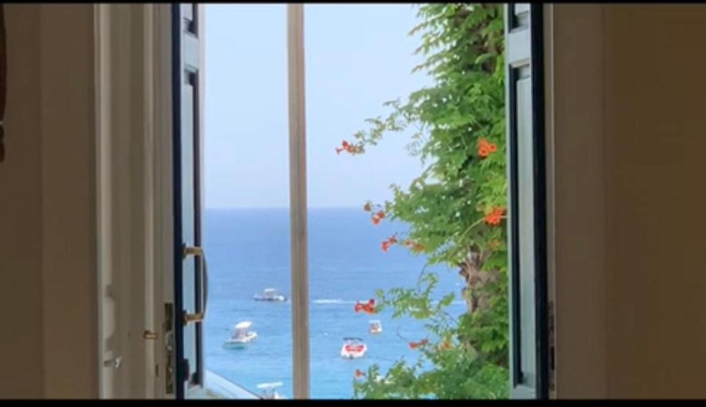 uma vista para o oceano a partir de uma janela aberta em La Vela em Castro di Lecce