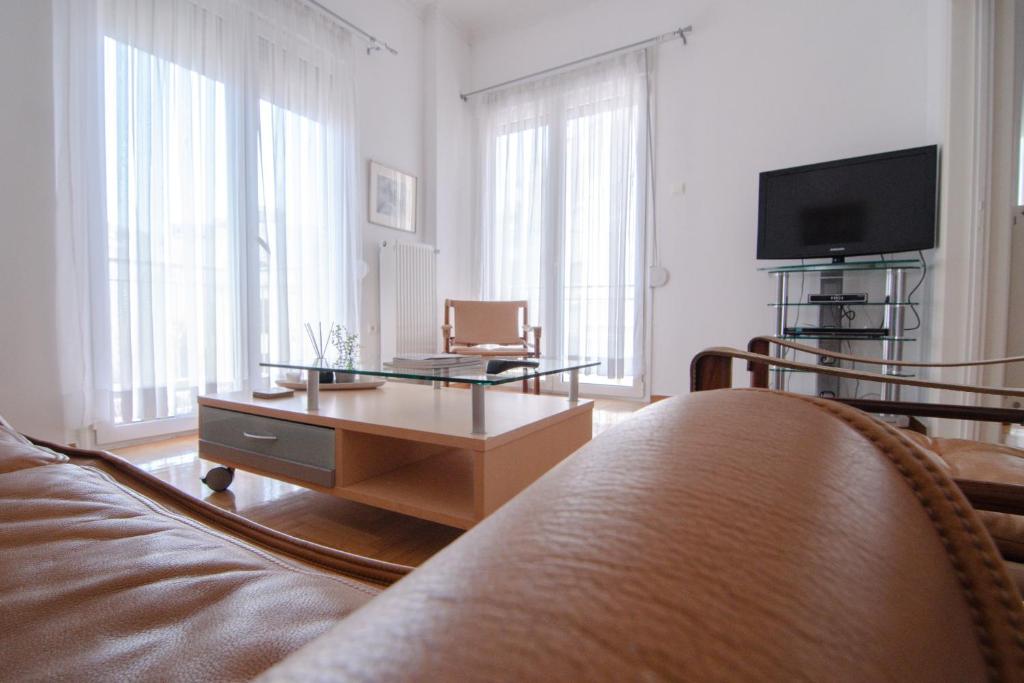 Cozy,fully equipped historic Athens apartment very close to Acropolis في أثينا: غرفة معيشة مع أريكة وطاولة قهوة