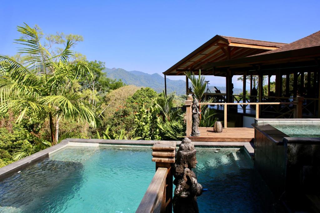 a swimming pool in front of a house at Uvita Bali Bosque Retreat in Uvita