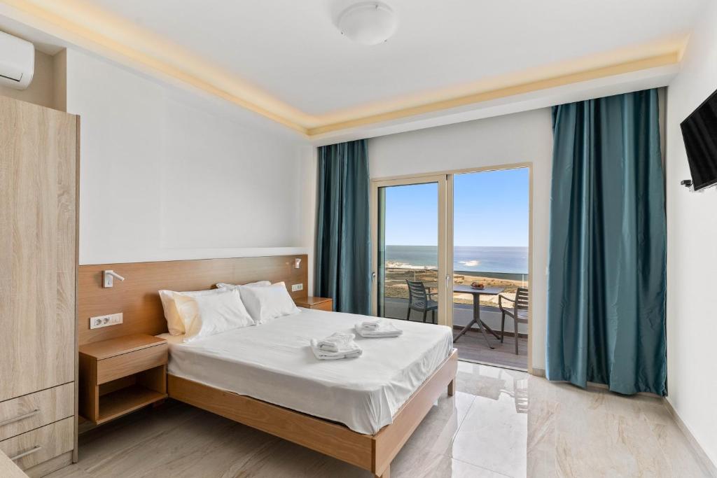 Mathios apartments Falassarna في فالاسارنا: غرفة نوم مع سرير وإطلالة على المحيط