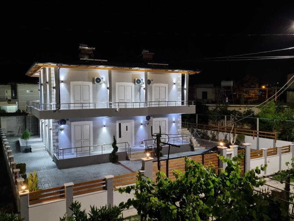 una casa bianca con le luci accese di notte di Vila Soleil a Vlorë