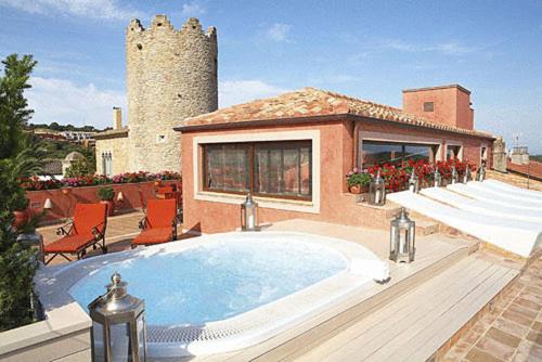 a house with a large swimming pool on a patio at Hotel Sa Calma in Begur
