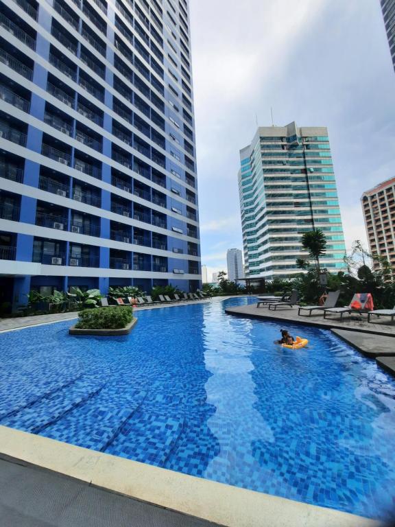 duży basen w mieście z wysokimi budynkami w obiekcie Stylish&Comfort Unit in Air Makati by Luca's Cove w mieście Manila