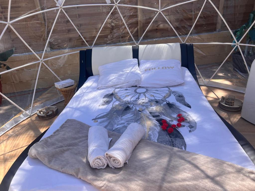 a bed with towels and a bouquet of flowers on it at Bulle insolite Fréjus in Fréjus
