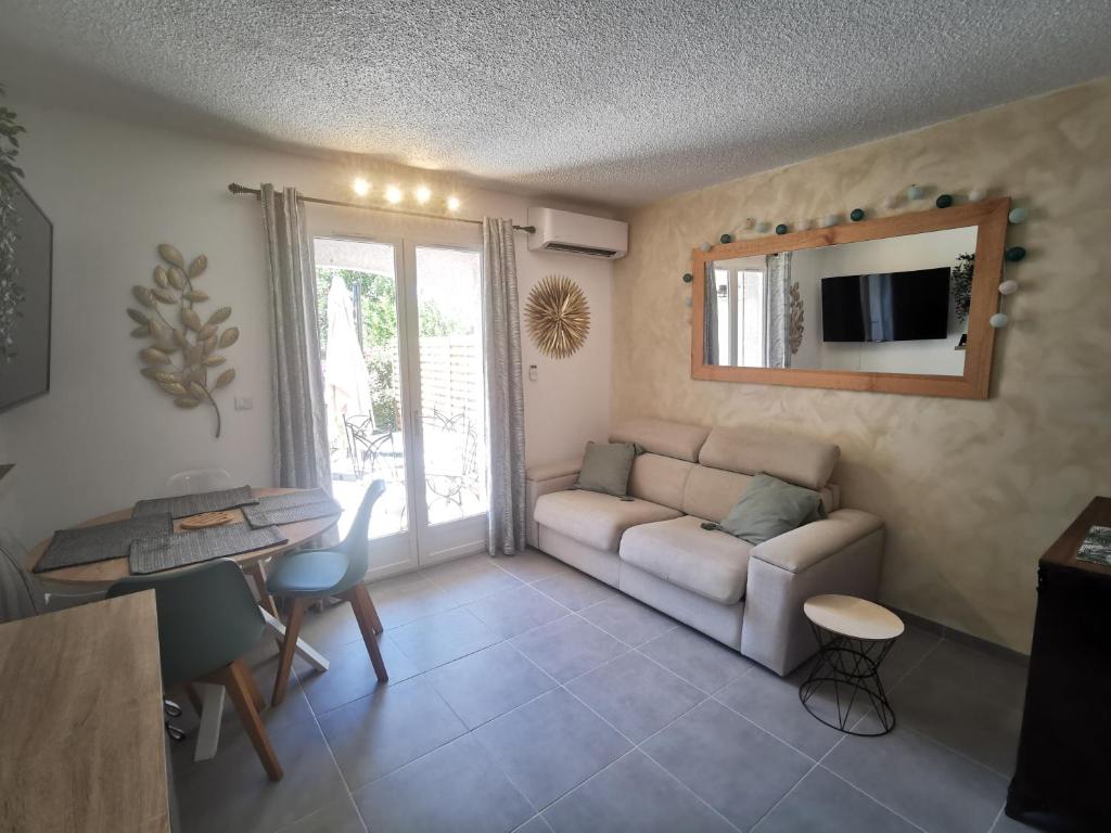 a living room with a couch and a table at La Terrasse Ensoleillée de Sausset : Le Citronnier in Sausset-les-Pins