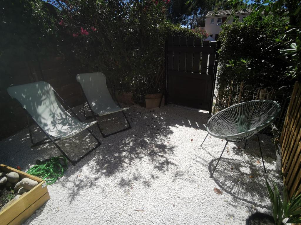 two chairs and a table in a backyard at La Terrasse Ensoleillée de Sausset : Le Citronnier in Sausset-les-Pins