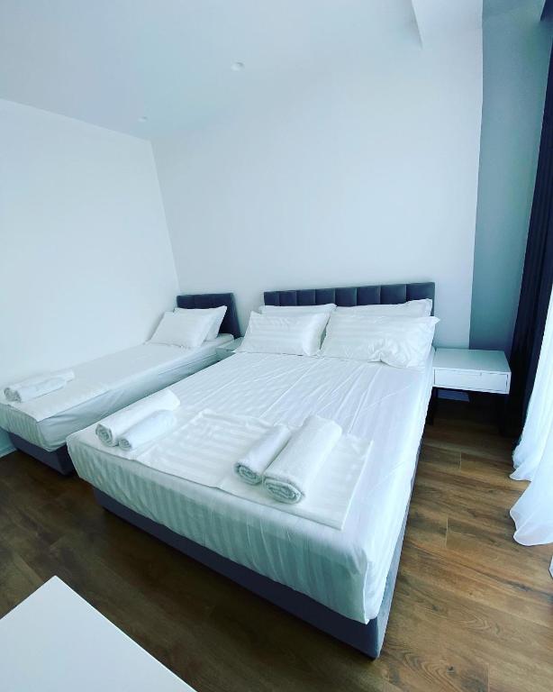 two beds in a room with white sheets and pillows at SEA & LAKE VIEW VILLA in (( Kalive Gjoka ))