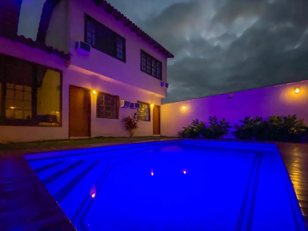 una piscina frente a una casa por la noche en Pousada Viva Geribá, en Búzios