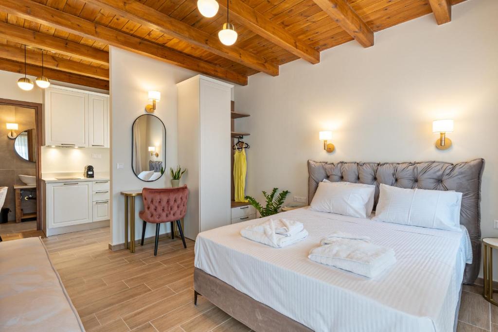 a bedroom with a large white bed and a kitchen at Casa Del Balsamo in Rethymno Town