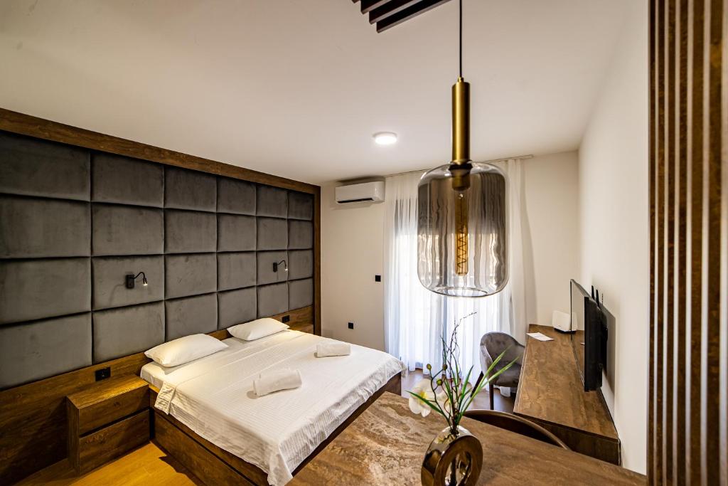 una camera con letto, scrivania e TV di Apartments Tulip Podgorica a Podgorica