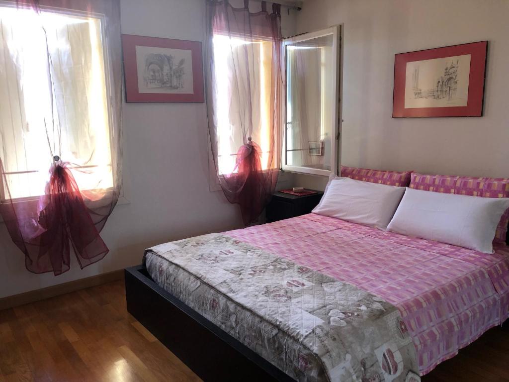 モリアーノ・ヴェーネトにあるResidence Flaviaのベッドルーム1室(ピンクベッド1台、窓2つ付)