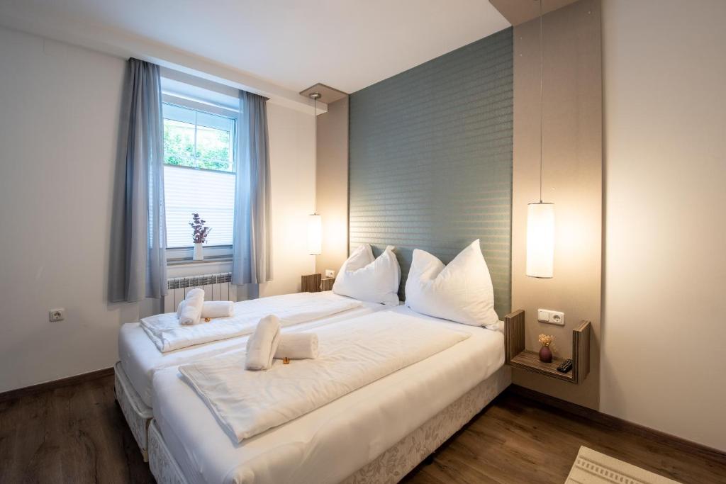 a large white bed in a room with a window at AMADEA - Cityhotel Salzburg in Salzburg