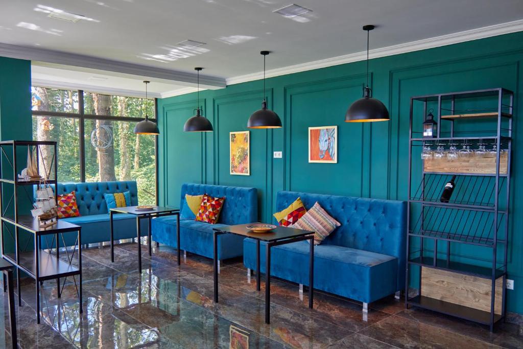 a living room with blue furniture and green walls at Villa Story Hotel in Shekvetili