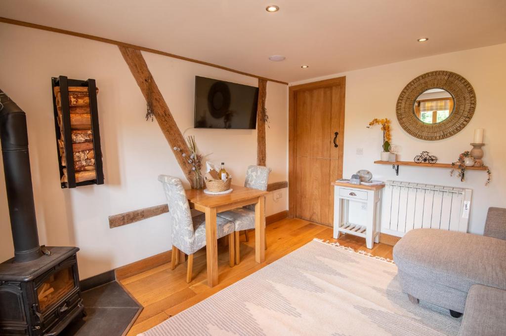 a living room with a table and a wood stove at Apple Tree Cottage - Cosy 2 Bed with Deluxe HOT TUB & Log Burner in Hereford