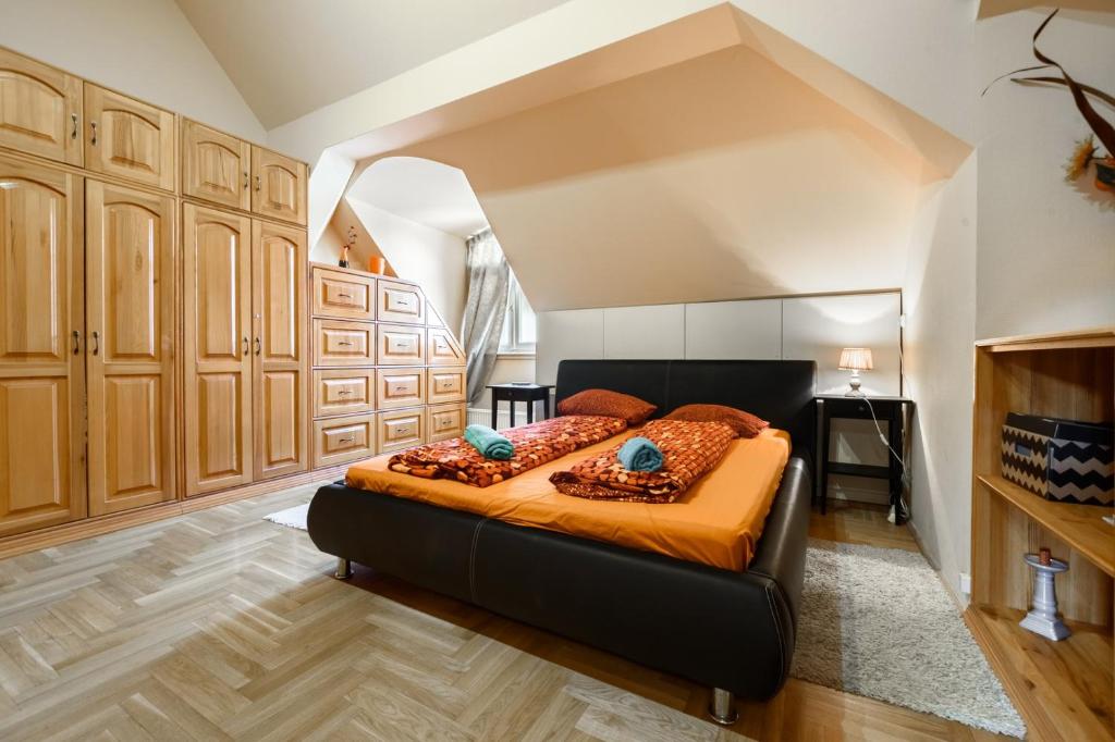 una camera da letto con letto con lenzuola arancioni e cuscini blu di View to the Roofs Luxury Apartment with 2 Bedrooms a Budapest