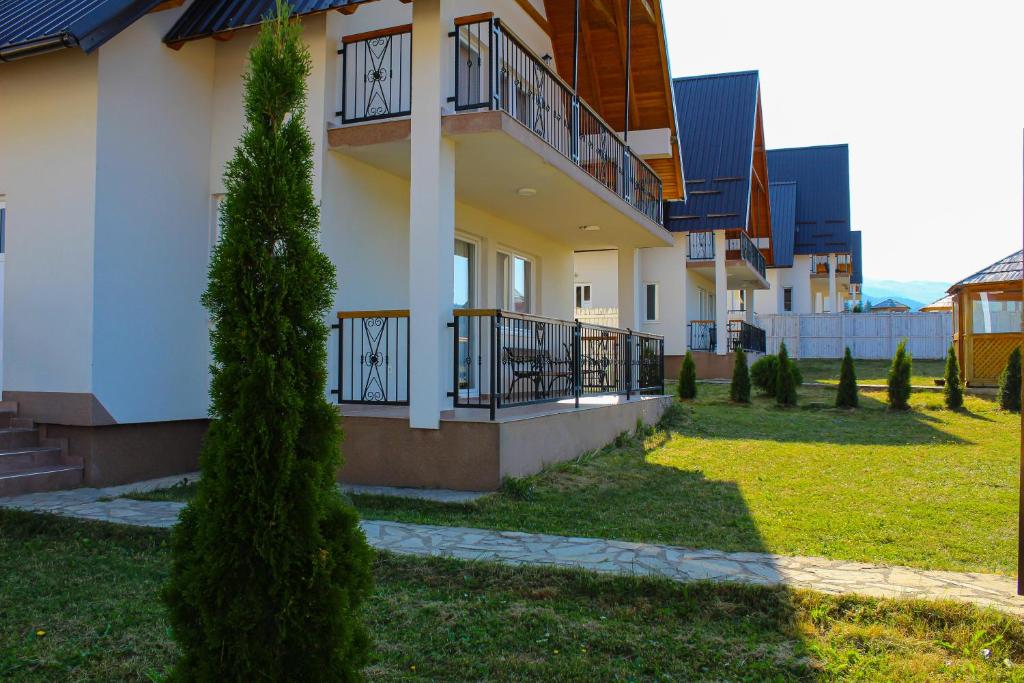 a house with balconies and a yard with a tree at Oaza Mira Hotel & Resort-فندق ومنتجع واحة الهدوء in Vlasic