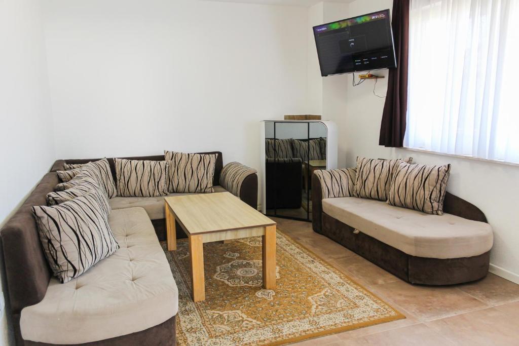 a living room with two couches and a tv at Oaza Mira Hotel & Resort-فندق ومنتجع واحة الهدوء in Vlasic