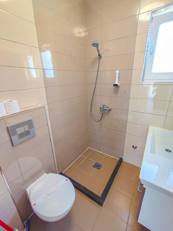 a bathroom with a toilet and a shower at Oaza Mira Hotel & Resort-فندق ومنتجع واحة الهدوء in Vlasic