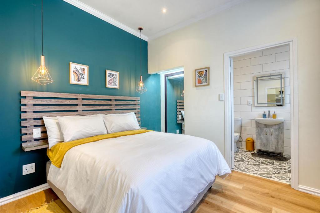 a bedroom with a large bed and a bathroom at Hampton Collection - Stylish 3 Sleeper Apartment with Pool in Durban